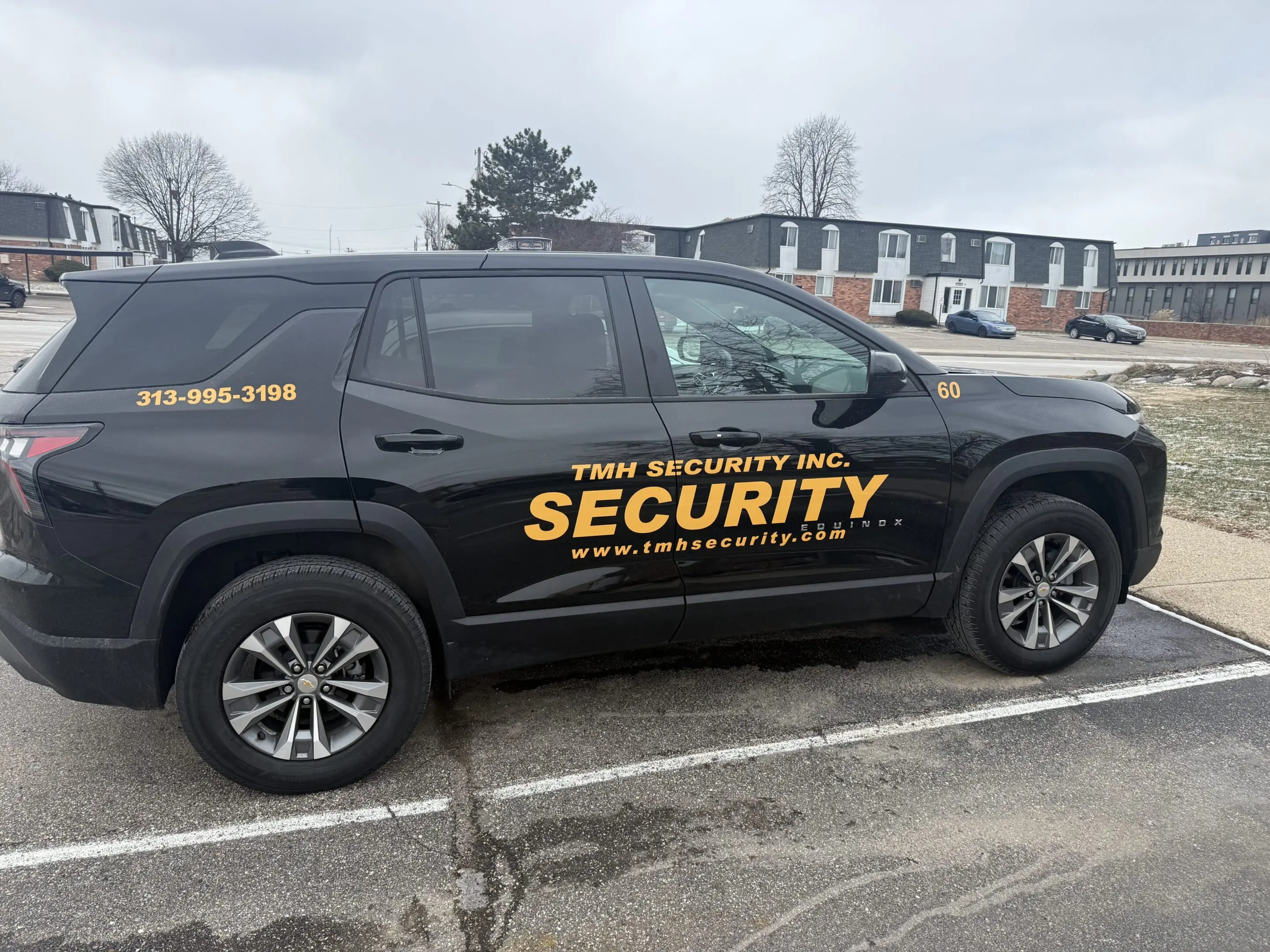 Black SUV with 'The Hughes Security' branding parked in a lot.
